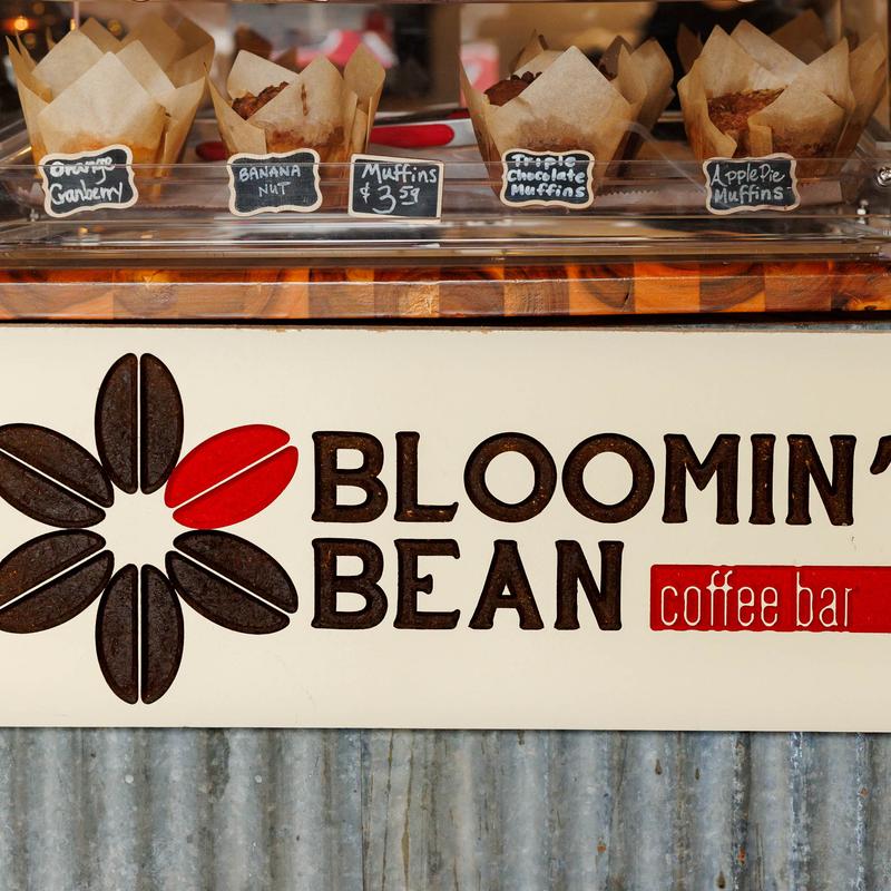Bloomin' Bean coffee bar sign with muffins on display