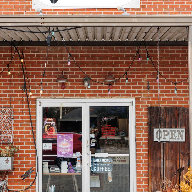 Brick storefront with string lights and an open sign