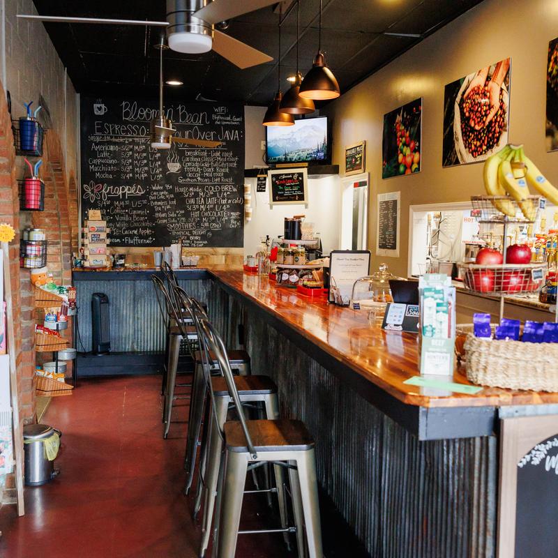 Cozy coffee bar with a wooden counter and metal stools