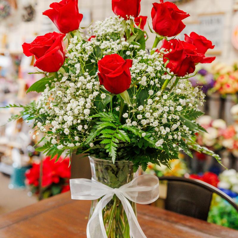Bouquet of red roses and baby's breath in a glass vase