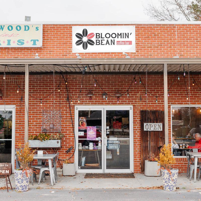 Bloomin Bean Coffee Bar storefront with outdoor seating and string lights